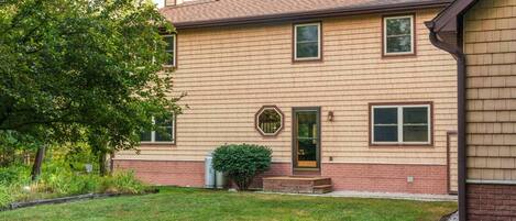 A two-story house with a brick foundation and a wooden exterior.