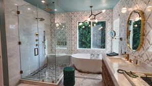 A modern bathroom with a glass-enclosed shower, a freestanding bathtub, and a vanity with dual sinks. - Charming 4-bedroom house in lovely Los Angeles with AC (Los Angeles)