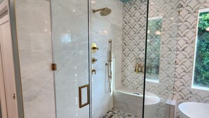 A modern bathroom with a glass-enclosed shower, a freestanding bathtub, and a vanity with a mirror. - Charming 4-bedroom house in lovely Los Angeles with AC (Los Angeles)