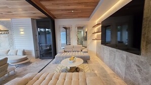 Un salon moderne avec un canapé, une table basse et un téléviseur fixé au mur.