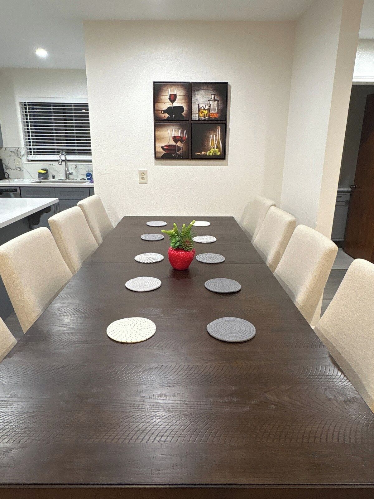 A conference room with a long table, six chairs, and a decorative centerpiece.