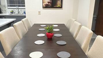 A conference room with a long table, six chairs, and a decorative centerpiece.