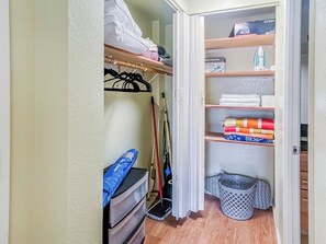 A closet with shelves, a hanging rack, and a storage bin. - Charming Twin-Joined Studio with Plentiful Space (Honolulu)