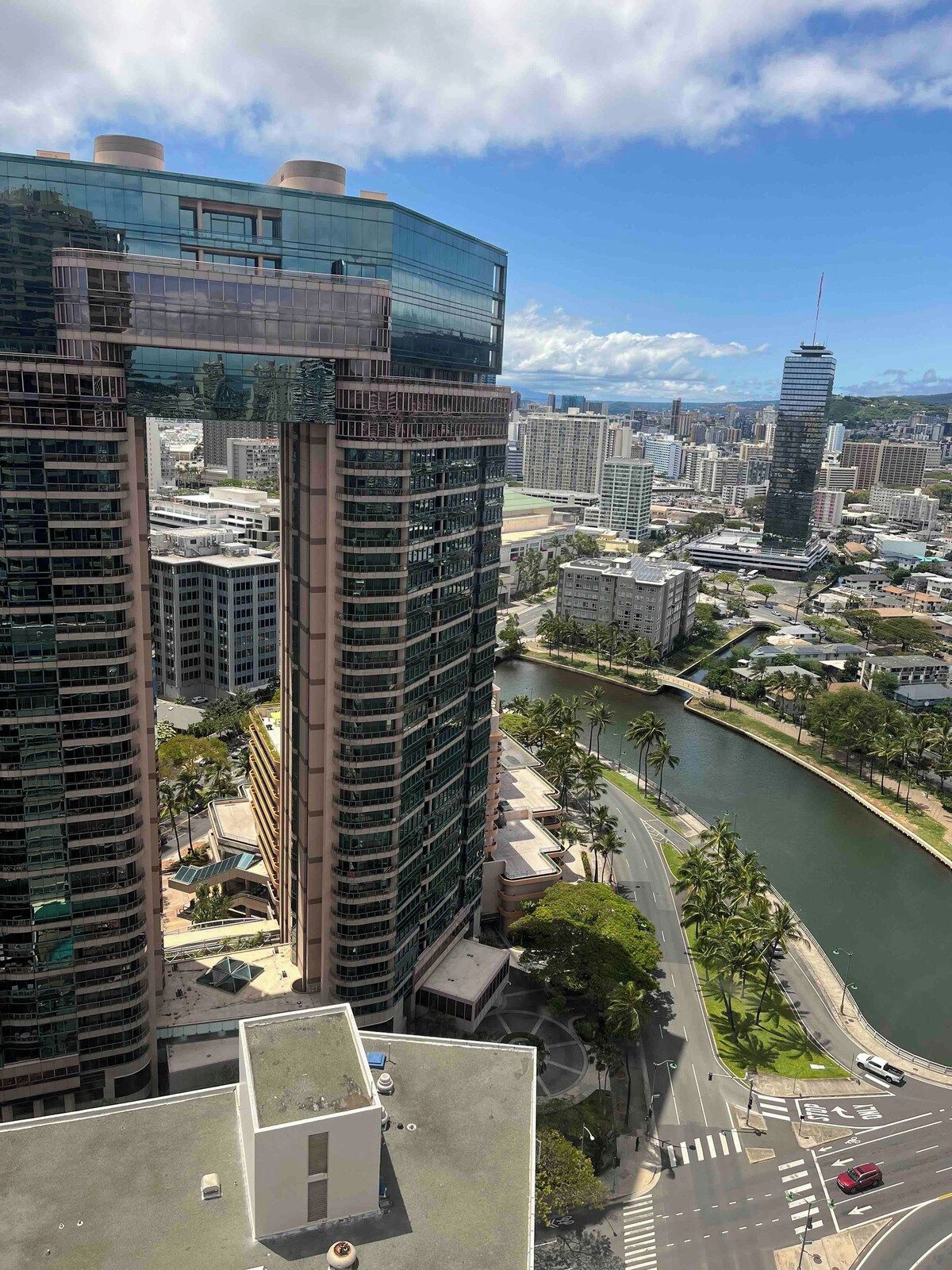 A high-rise building with a glass facade and a river running alongside.