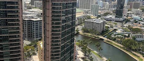 A high-rise building with a glass facade and a river running alongside.