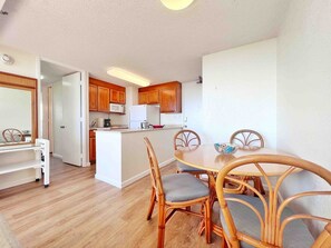 Una cocina compacta con muebles de madera, un microondas y un refrigerador.
