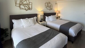 A hotel room with two beds, each with a nightstand, a lamp, and a geometric wall decoration. - A Clean Homie Getaway, Double Bed Studio 2 a VIEW (Honolulu)
