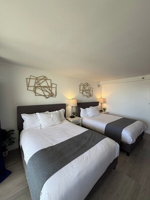 A hotel room with two beds, each with a nightstand, a lamp, and a geometric wall decoration. - A Clean Homie Getaway, Double Bed Studio 2 a VIEW (Honolulu)