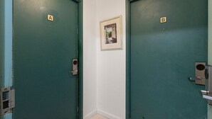 Dos puertas, identificadas con las letras A y B, un cuadro en la pared y un interruptor de luz en la puerta.