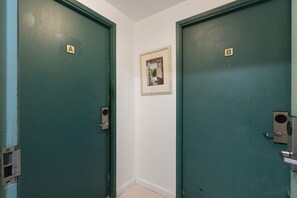 Dos puertas, identificadas con las letras A y B, un cuadro en la pared y un interruptor de luz en la puerta.