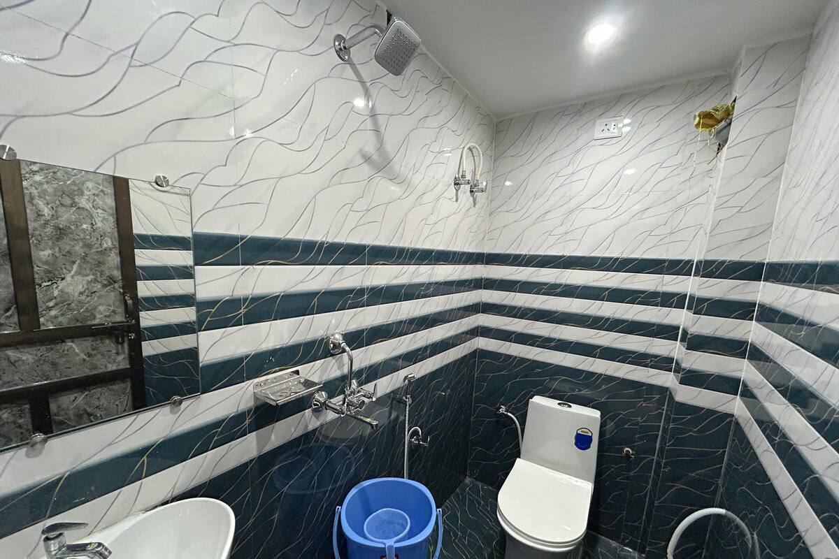 A bathroom with a marble vanity, a sink, a toilet, and a shower.