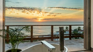 A balcony with a view of the sunset over the ocean, a potted plant, and a metal railing. - Villa Solara | Panoramic Ocean views & Luxury Mountaun Retreat villa (San Jose del Cabo)