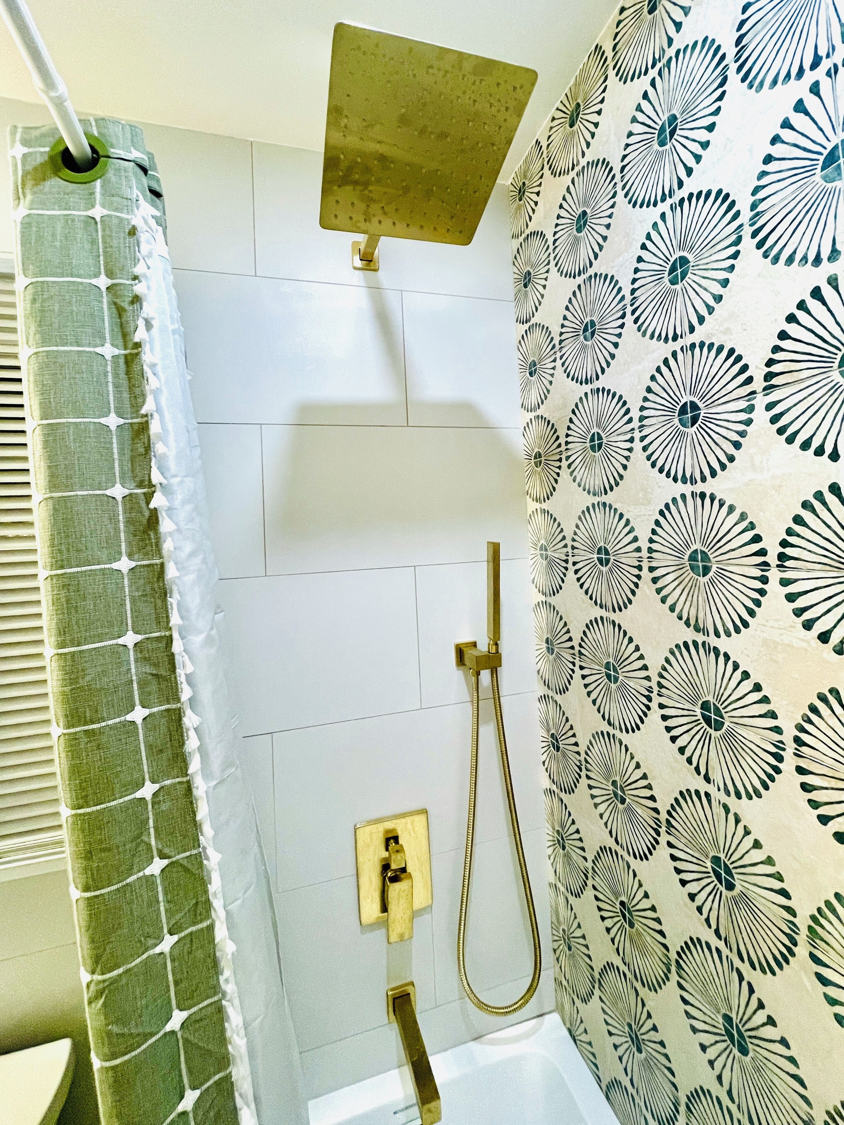 Une salle de bain avec une douche, un porte-serviettes et un rideau de douche à motifs.