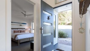 A bedroom with a bed, a ceiling fan, and a nightstand. - Low Head Coastal Haven: Your Seaside Escape (George Town)