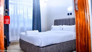 A hotel room with a bed, a curtain, and a window. - Saimo Hotel Kabarnet (Kabarnet)