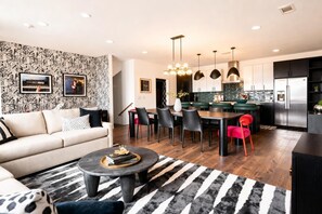 Ein modernes Wohnzimmer mit Sofa, Couchtisch und einem gemusterten Teppich.