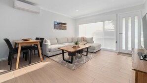 Una sala de estar moderna con un sofá, una mesa de centro y un comedor.
