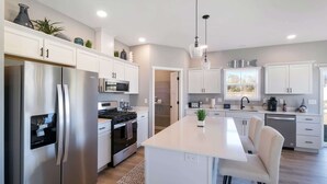 Una cocina moderna con electrodomésticos de acero inoxidable, una isla central y vistas al exterior.