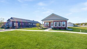 A residential area with two houses, one with a dark exterior and another with a red exterior. - Harbor Village Neighborhood at Heritage Harbor (Ottawa)