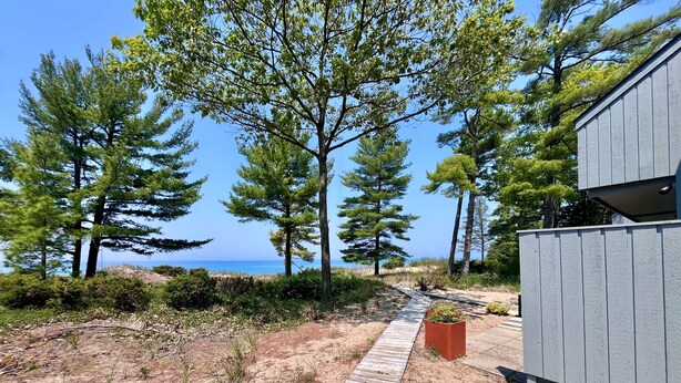 Un sendero de madera que lleva a un edificio con vista al mar.