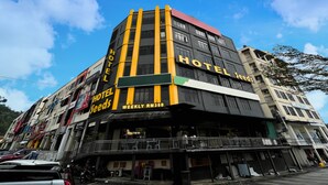 Ein mehrstöckiges Hotel mit einer gut sichtbaren "HOTEL"-Beschriftung an der Fassade, das eine Wochenrate von RM350 bietet.