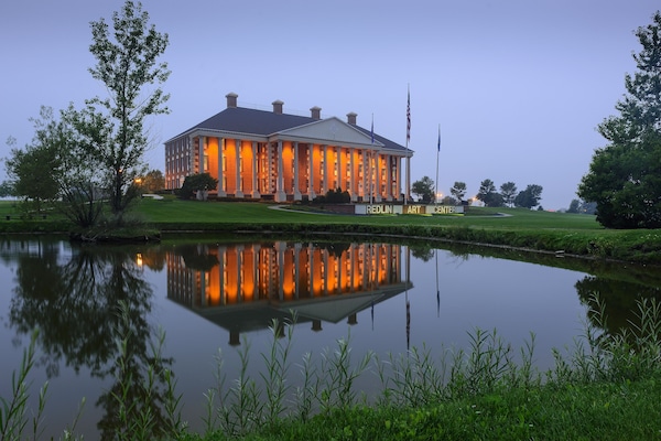 Arrive at a glowing lakeside landmark with mirror-like reflections.
