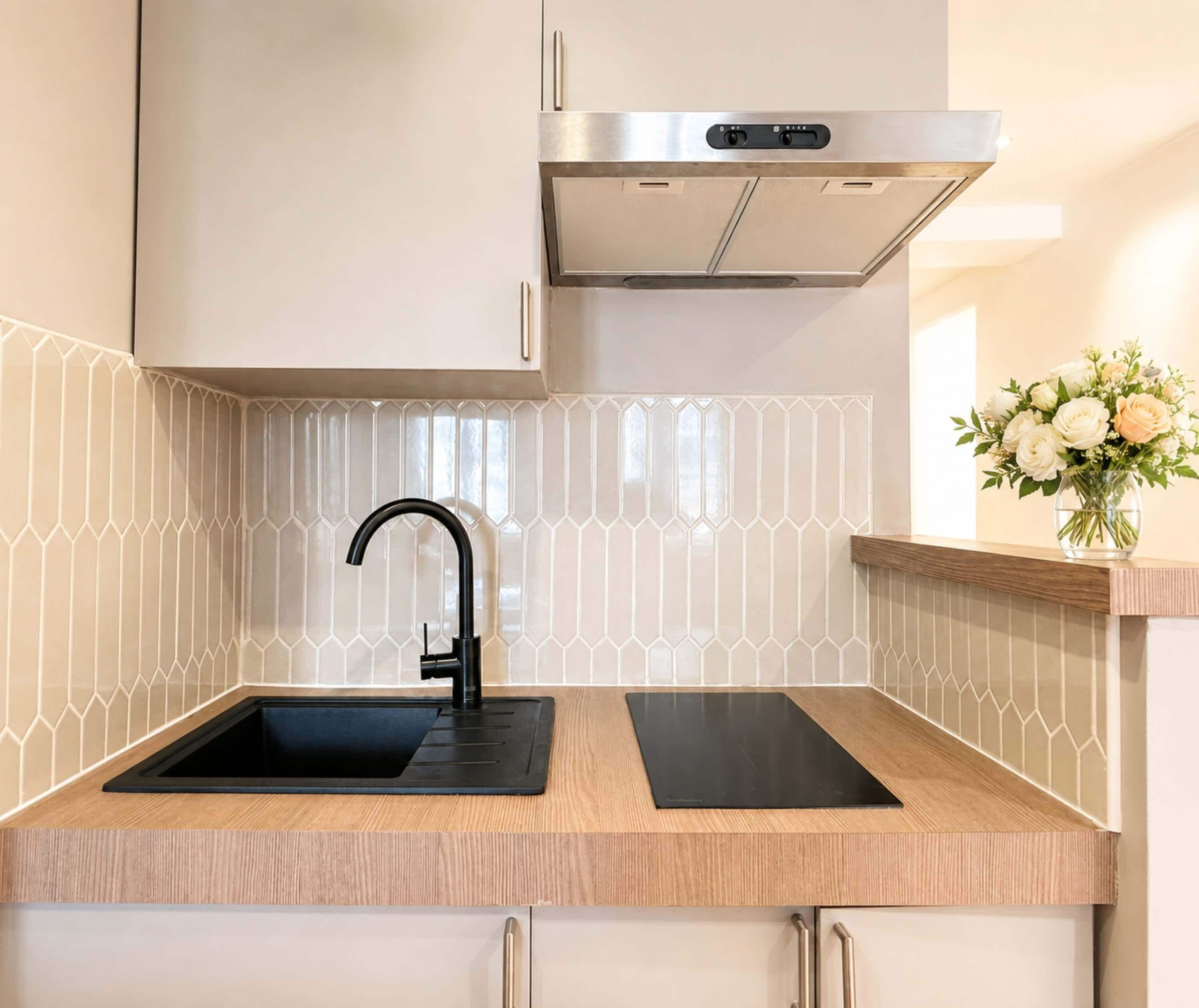 A modern kitchen with a black faucet, stainless steel range hood, and a wooden countertop.