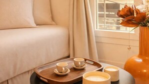 A cozy room with a bed, a small round table with candles, and a vase with flowers. - Marais stylish & central studio (Paris)