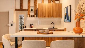 A modern kitchen with wooden cabinets, a central island with bar stools, and a decorative vase.
