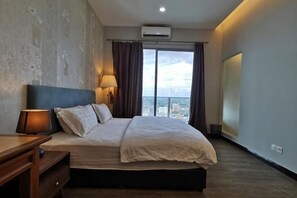 Une chambre d’hôtel avec un lit, un bureau, une lampe, une vue sur la ville et une grande fenêtre.
