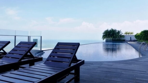 A rooftop pool with lounge chairs and a clear view of the ocean. - Mykey Silverscape B-39-06 Melaka City (Melaka)