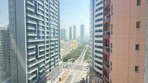 A high-rise building with multiple floors, large windows, and a modern architectural design. - Premium Studio In Jvc Bazr (Dubai)