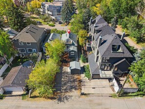 An aerial view of a residential area with multiple two-story houses, a central courtyard, and surrounding greenery. - The Sunny | 2 Suites | 10 Pax | Pet Friendly Stay! (Calgary)