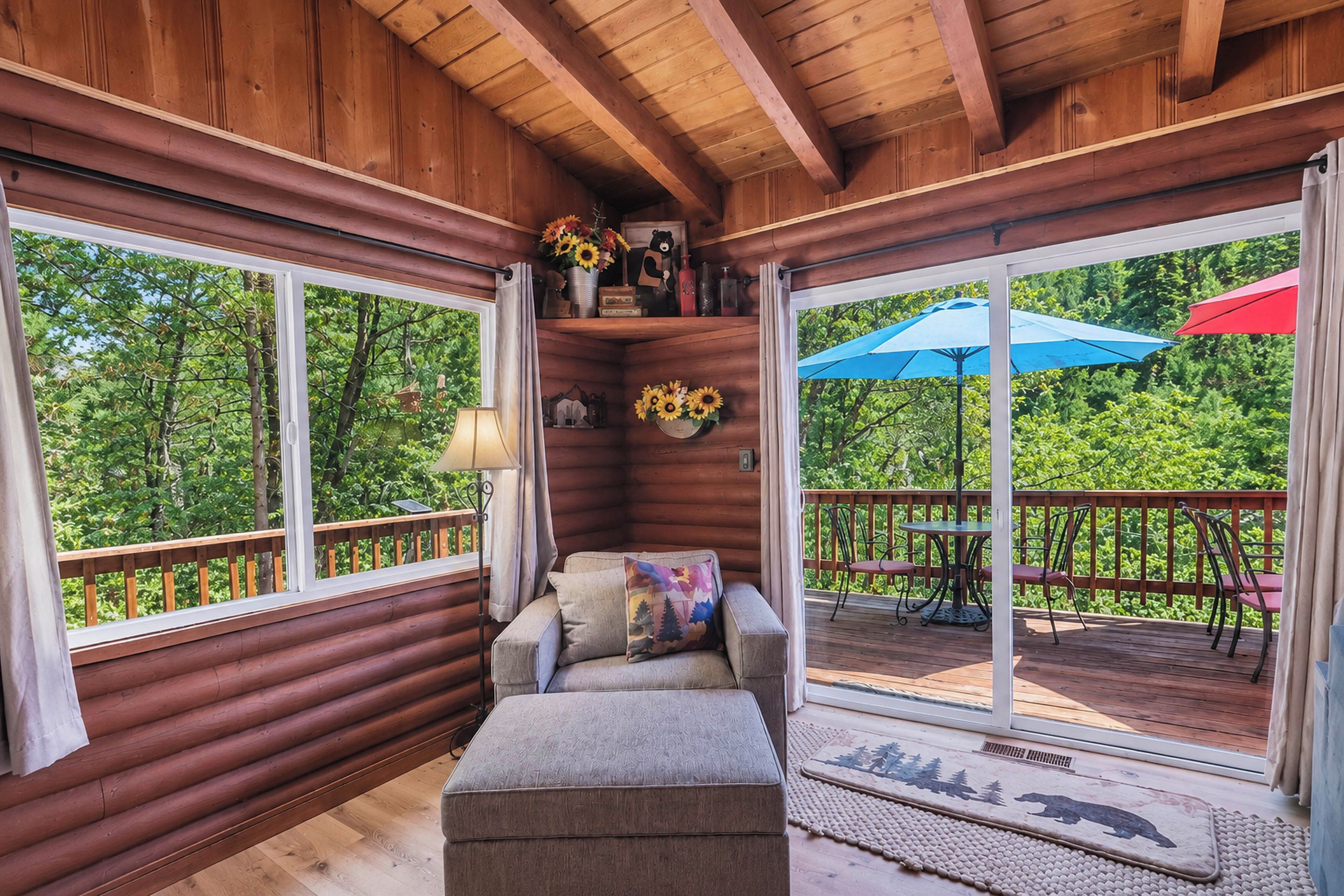A log cabin interior with a sofa, a small table, and a window overlooking a deck.