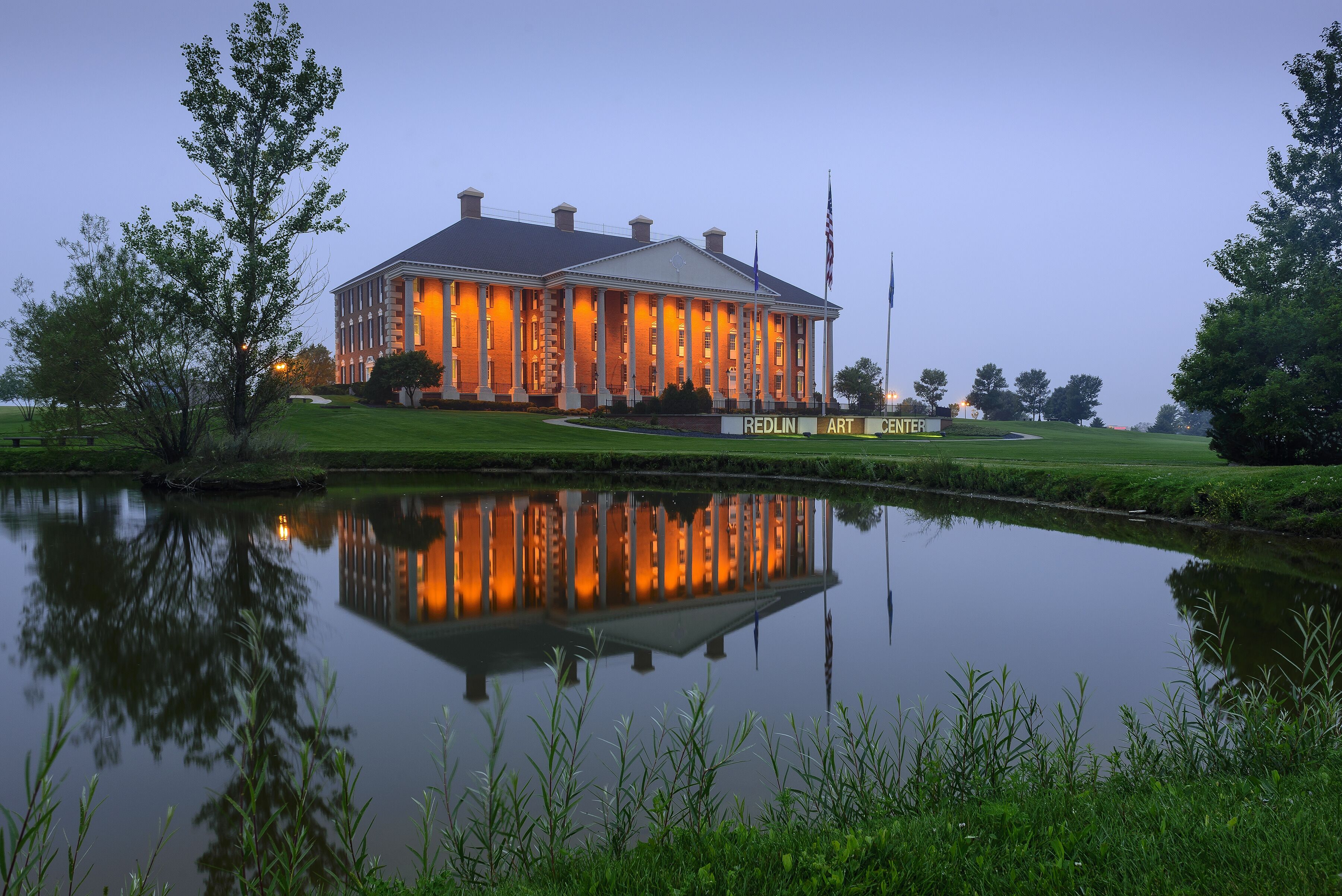 Arrive at a glowing lakeside landmark with mirror-like reflections.