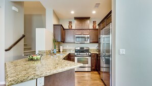 A modern kitchen with granite countertops, stainless steel appliances, and wooden cabinets. - Oceanside Extended Stay Near Camp Pendleton (Oceanside)