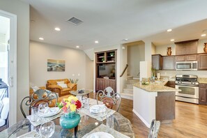 A modern kitchen with a central island, stainless steel appliances, and wooden cabinets.