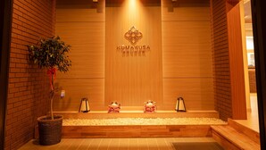 A wooden reception area with a sign reading "KOMAKUSA". - Komakusa Hotel (Matsumoto)