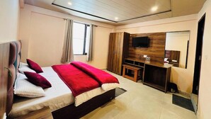 Une chambre d’hôtel moderne équipée d’un grand lit, d’une télévision, d’un bureau et d’une armoire.