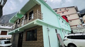 Un immeuble de deux étages doté d’un balcon à l’étage supérieur, d’une façade en briques et d’une enseigne indiquant qu’il s’agit d’un hôtel.