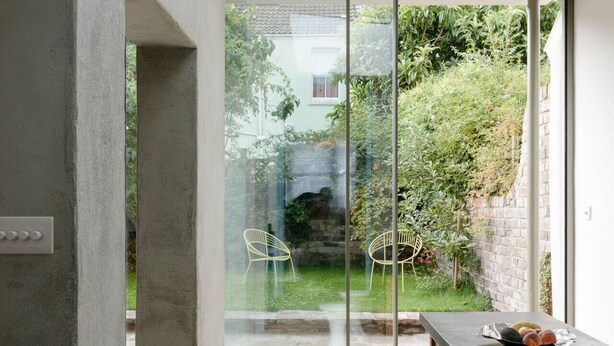 A modern interior with a skylight, a dining area with a table and chairs, and a view of a garden through large glass doors. - Beautiful 3 Bedroom Home in Bristol (Bristol)