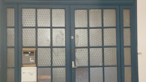 Une porte à deux battants avec des panneaux en verre dépoli et un lecteur de carte à puce installé sur le côté gauche.