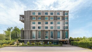 Een modern, meerlaags hotel met een symmetrische gevel, grote ramen en een centrale ingang.
