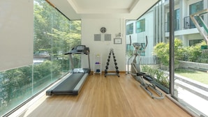 Een moderne sportschool met een loopband, gewichten en trainingsapparatuur.