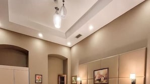 A hotel room with two beds, a wardrobe, a desk, and a chair. - Bella Garden Hotel (Baku)