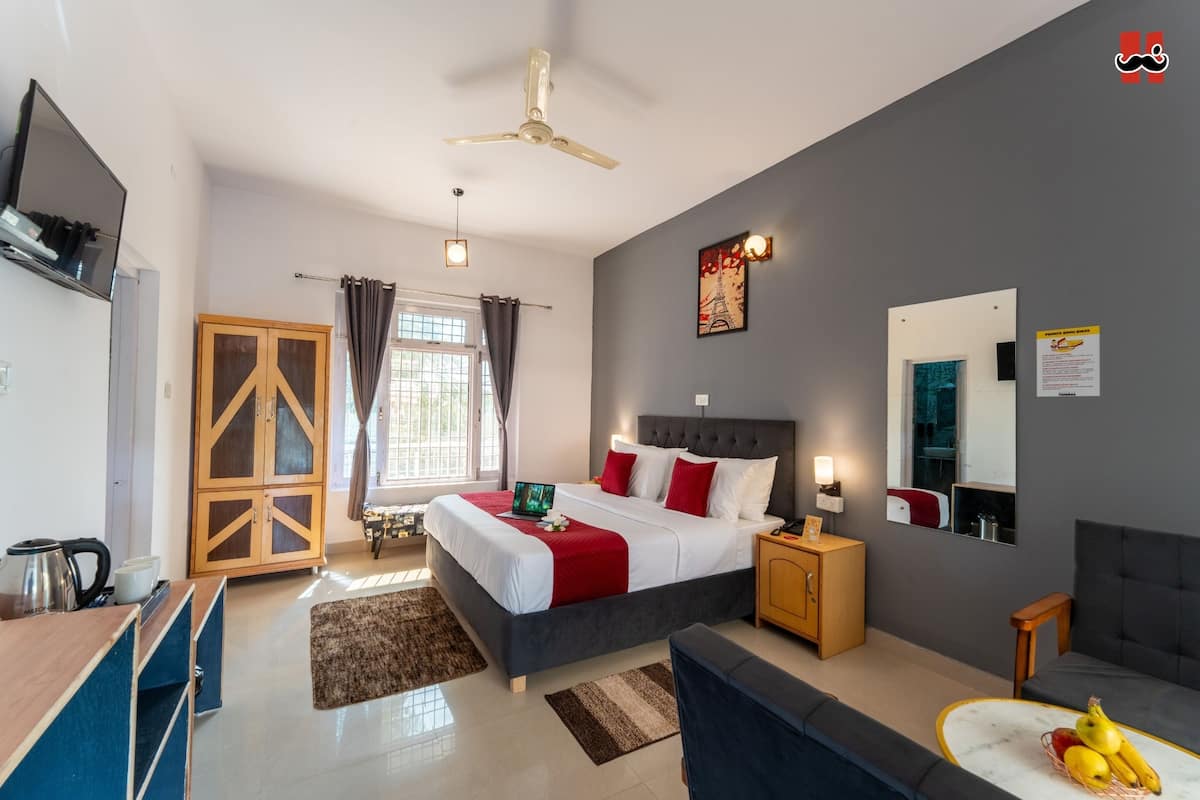 A modern bedroom with a bed, bedside table, and a desk area.