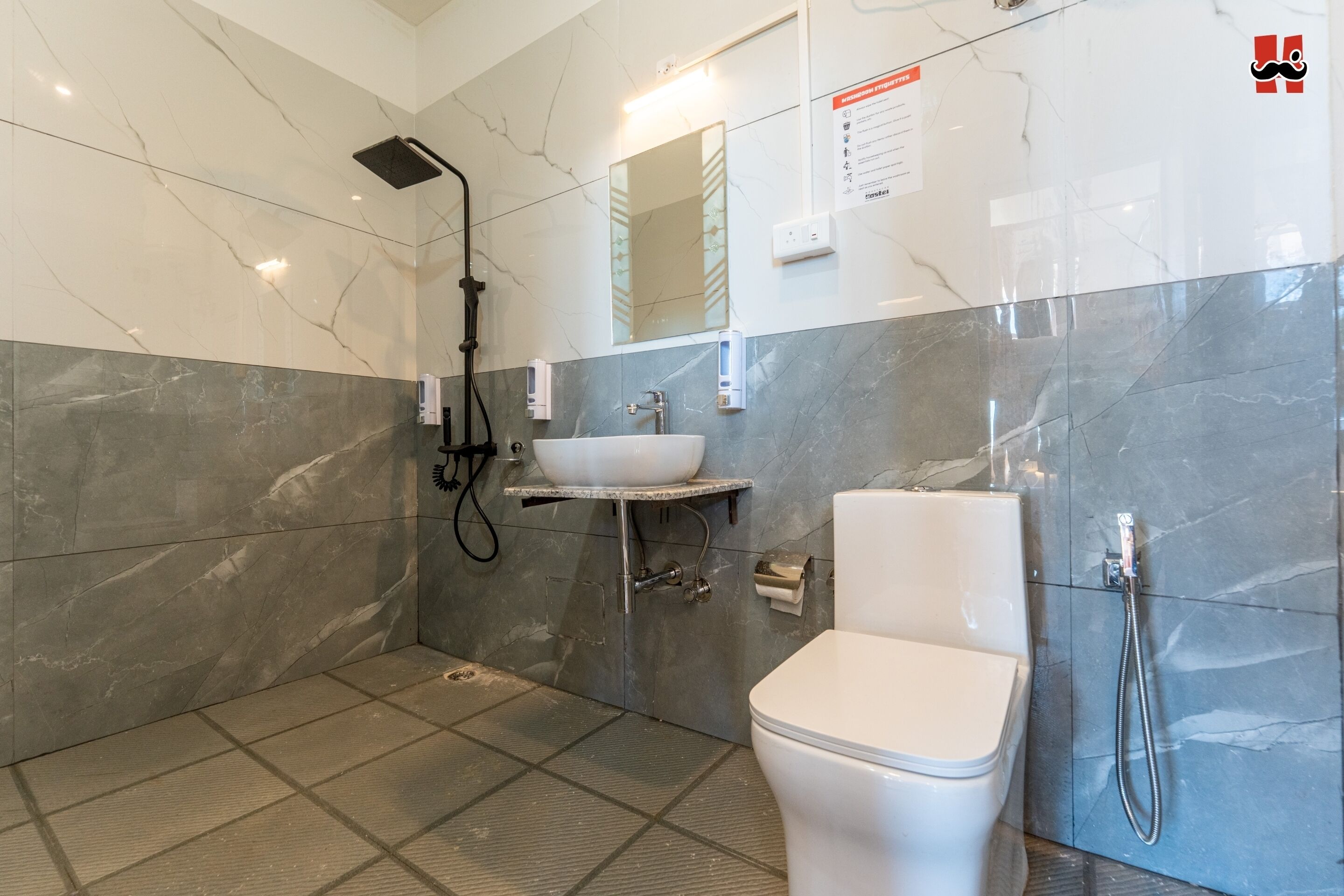A modern bathroom with a white toilet, a sink, and a shower.