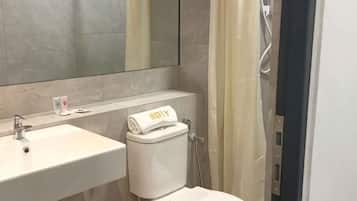 A bathroom with a sink, toilet, and shower.