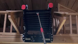 Eine Küche mit Holzausstattung, einer Edelstahlspüle und einem Werkzeug mit rotem Griff.