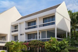 A multi-story hotel with balconies, a flat roof, and a garden area. - Molly Beach House by Yudee Assets (Hua Hin)